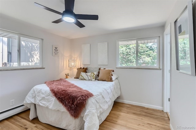 bedroom featuring baseboard heating, ceiling fan, and light wood-type flooring