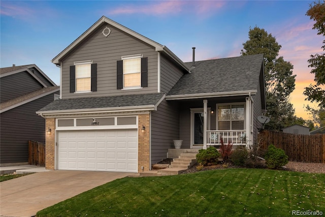 front facade featuring a garage, a porch, and a yard