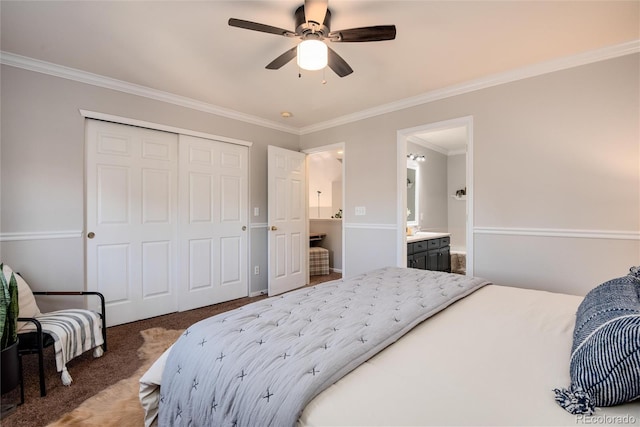 carpeted bedroom with ensuite bath, a closet, ceiling fan, and crown molding