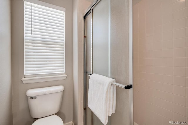 bathroom with toilet and a shower with shower door