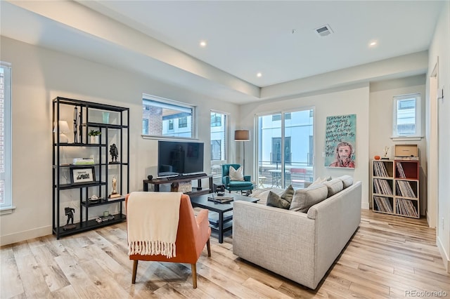 living room with plenty of natural light and light hardwood / wood-style flooring