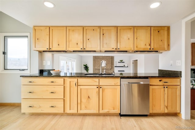 kitchen with dishwasher, light brown cabinetry, dark stone counters, and a sink