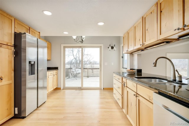 kitchen with a sink, light brown cabinetry, dishwasher, and stainless steel fridge with ice dispenser