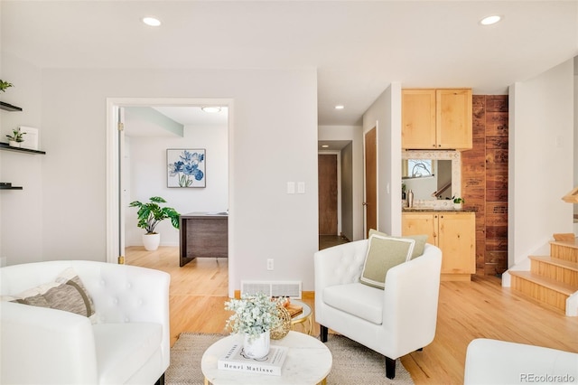 living room featuring recessed lighting, visible vents, baseboards, stairs, and light wood finished floors