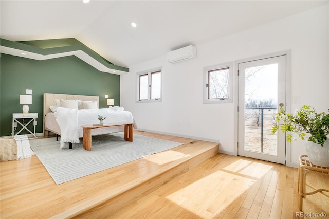 bedroom with a wall unit AC, recessed lighting, wood finished floors, access to exterior, and vaulted ceiling