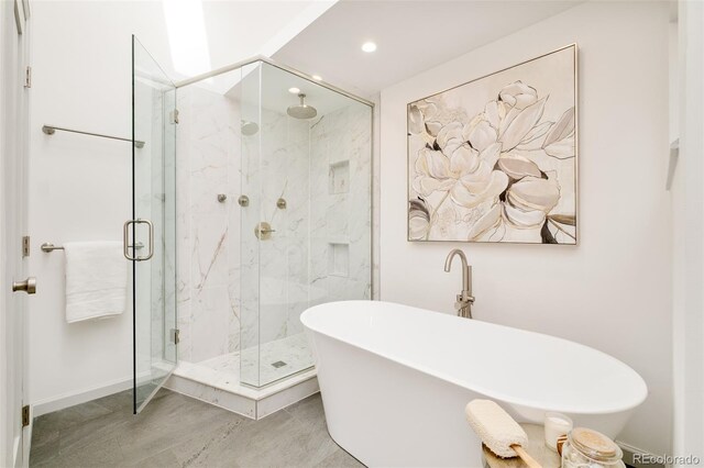 full bath with a soaking tub, a marble finish shower, and recessed lighting