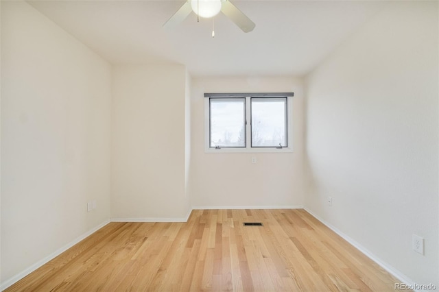 empty room featuring light wood-type flooring, ceiling fan, visible vents, and baseboards