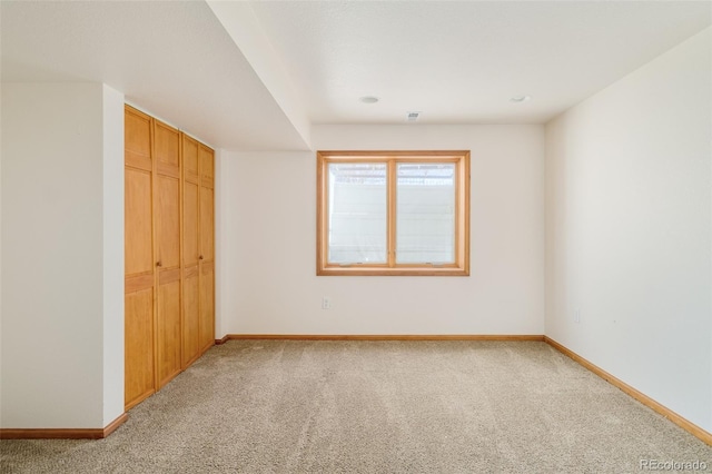 unfurnished bedroom with baseboards, a closet, and light colored carpet