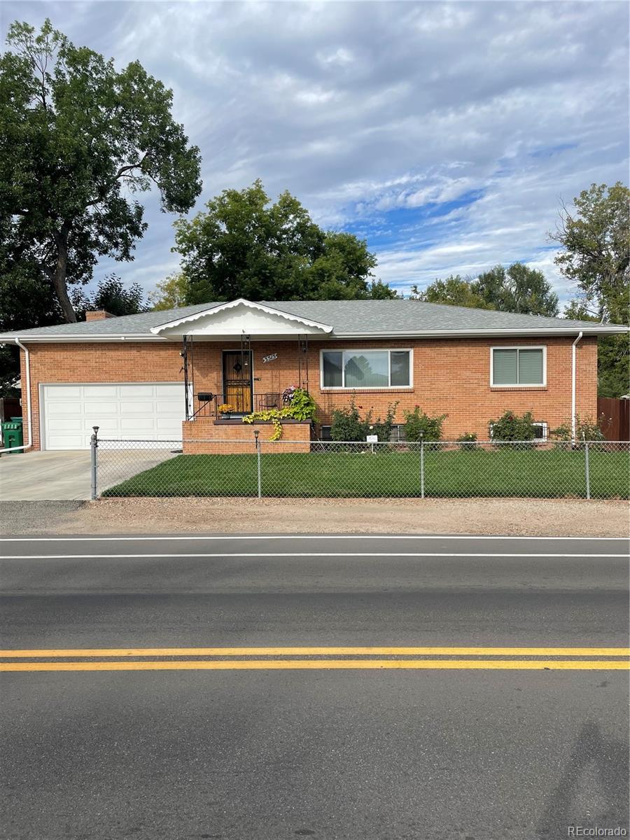 ranch-style home featuring a garage and a front lawn