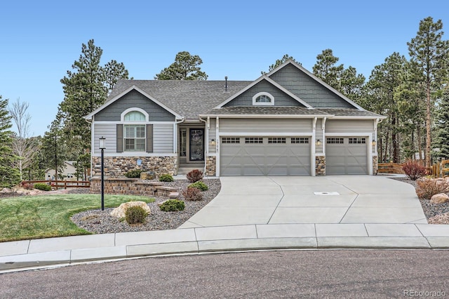 craftsman house with an attached garage, stone siding, a front yard, and concrete driveway