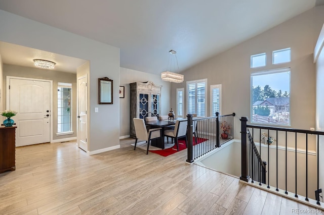 interior space featuring lofted ceiling, light wood finished floors, and plenty of natural light