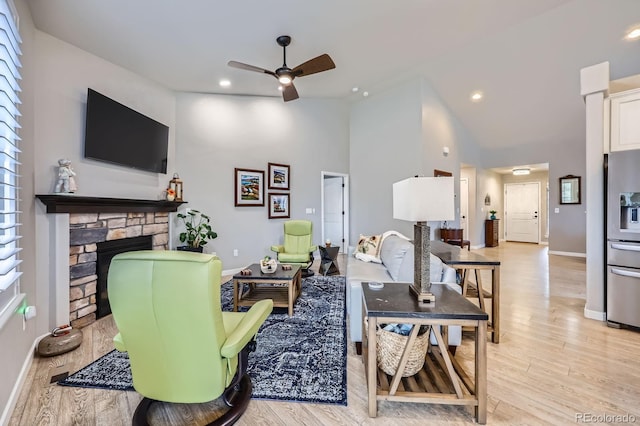 living room with baseboards, a ceiling fan, and light wood finished floors
