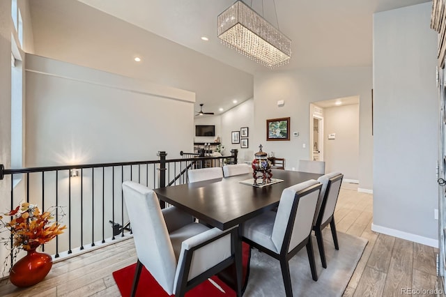 dining space with recessed lighting, light wood-type flooring, baseboards, and ceiling fan with notable chandelier