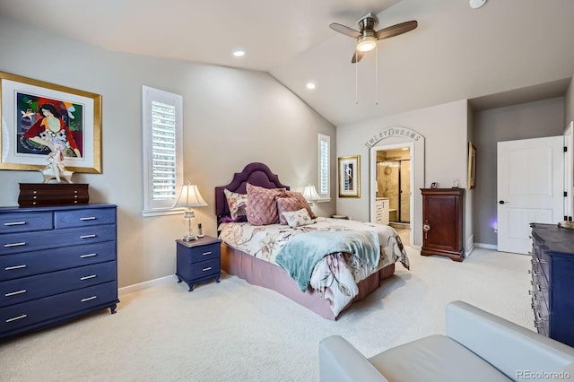 bedroom featuring light carpet, baseboards, lofted ceiling, a ceiling fan, and connected bathroom