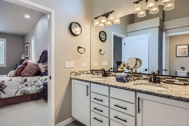 ensuite bathroom featuring a sink, double vanity, and connected bathroom