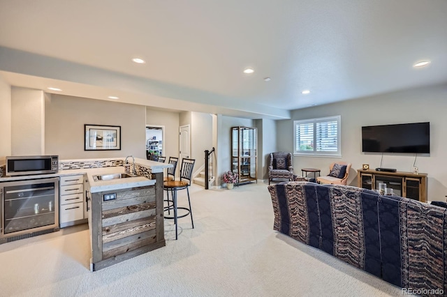 living room featuring stairway, light carpet, beverage cooler, and recessed lighting