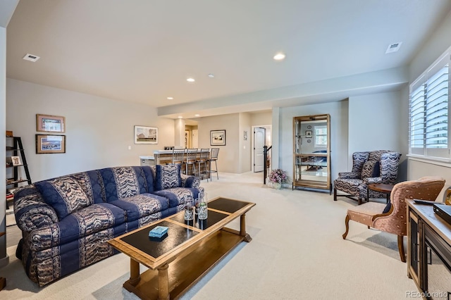 living room with visible vents, recessed lighting, and light colored carpet