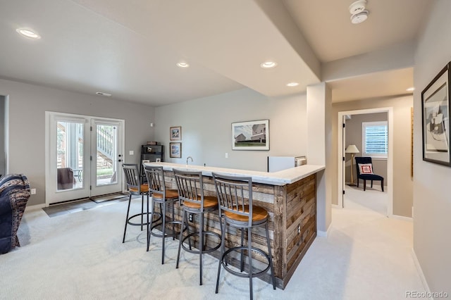 kitchen with baseboards, light carpet, and recessed lighting