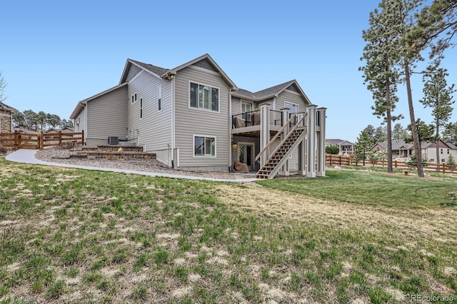 back of house with stairway, a lawn, fence, and a deck