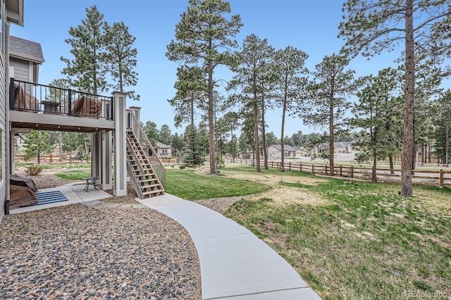 view of yard featuring a patio area, fence, stairway, and a deck