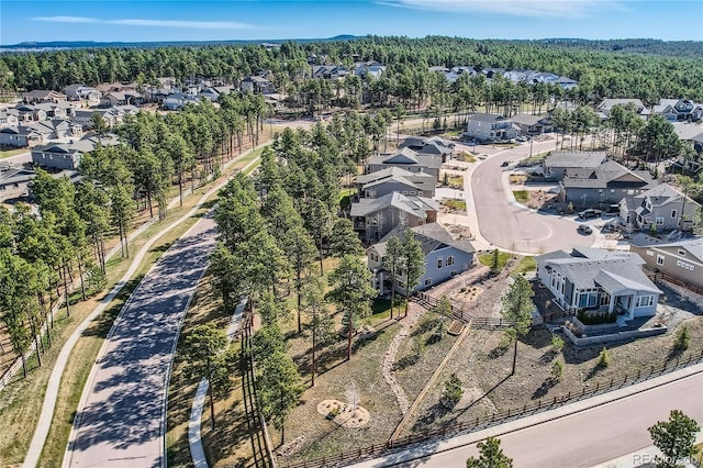 drone / aerial view featuring a residential view and a wooded view