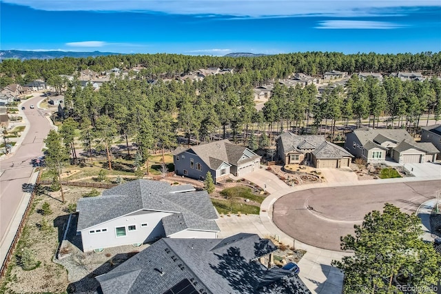 aerial view featuring a wooded view and a residential view