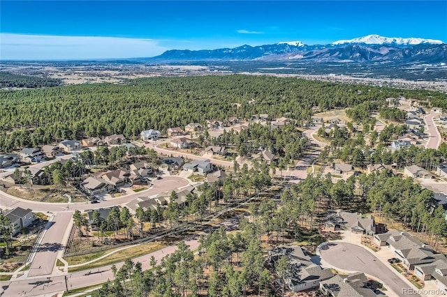 birds eye view of property with a residential view, a wooded view, and a mountain view