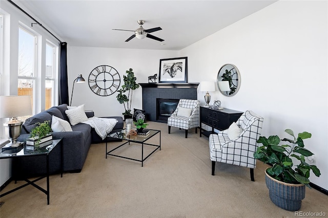 living room featuring light carpet, a fireplace, and ceiling fan