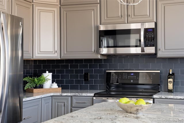 kitchen featuring tasteful backsplash, stainless steel appliances, and light stone countertops