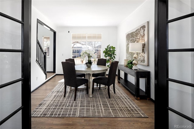 dining space featuring wood-type flooring and ornamental molding