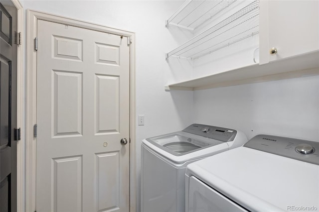 laundry room with washing machine and dryer and cabinets