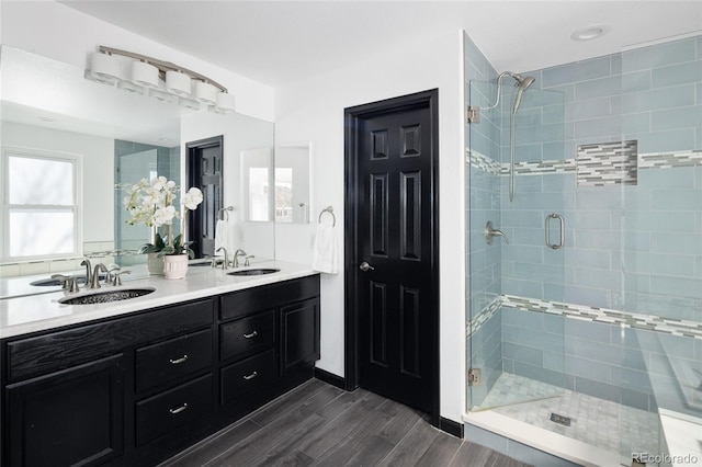 bathroom featuring wood-type flooring, an enclosed shower, and vanity