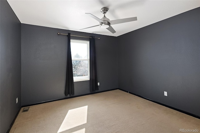 empty room featuring light colored carpet and ceiling fan