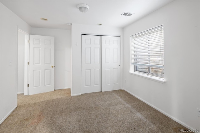 unfurnished bedroom featuring carpet floors and a closet