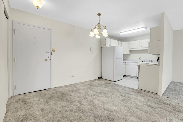 kitchen with light countertops, hanging light fixtures, light carpet, white cabinetry, and white appliances