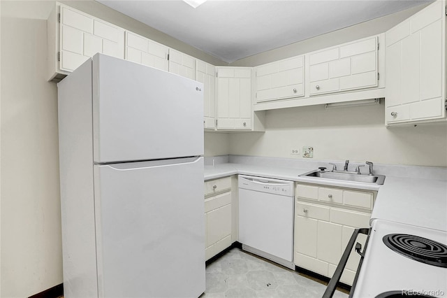 kitchen featuring white appliances, light countertops, a sink, and white cabinetry