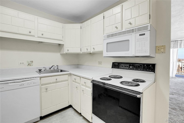 kitchen featuring white cabinets, white appliances, light countertops, and a sink