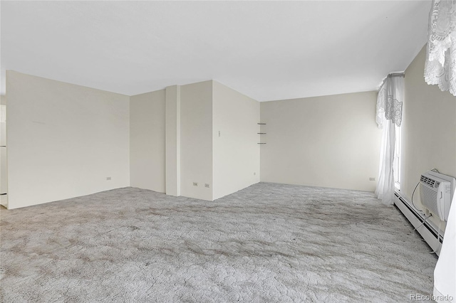 spare room featuring light carpet and baseboard heating