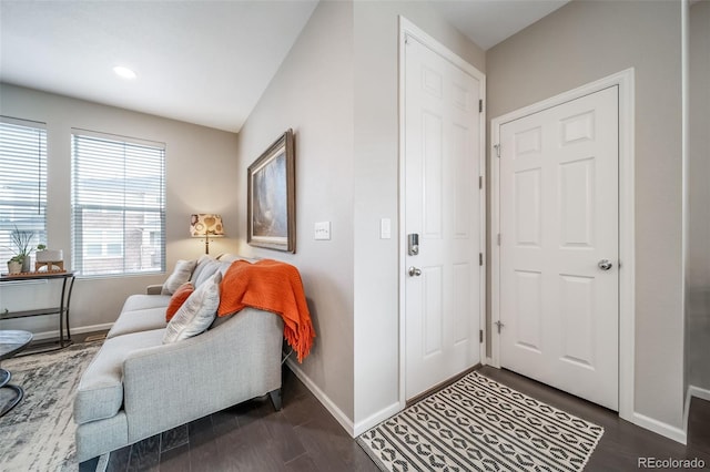 foyer featuring baseboards and dark wood-type flooring