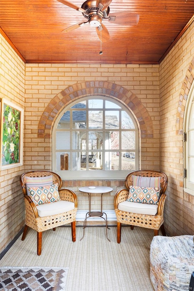 sitting room with brick wall and wood ceiling