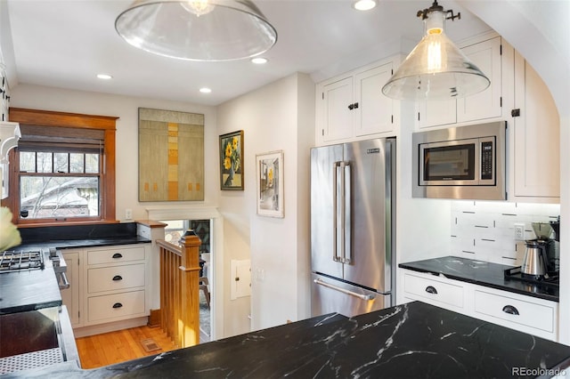 kitchen featuring tasteful backsplash, light wood-type flooring, recessed lighting, stainless steel appliances, and white cabinetry