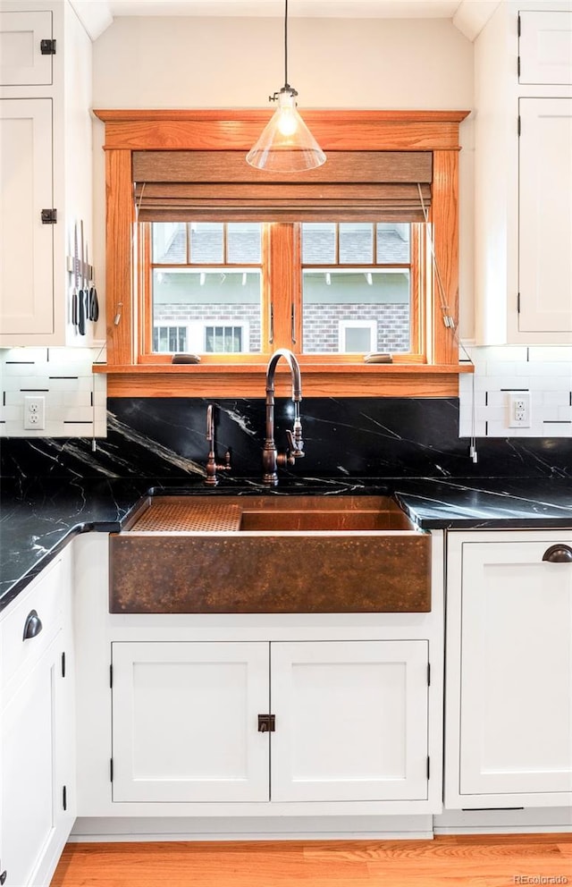 kitchen featuring white cabinetry, plenty of natural light, tasteful backsplash, and a sink