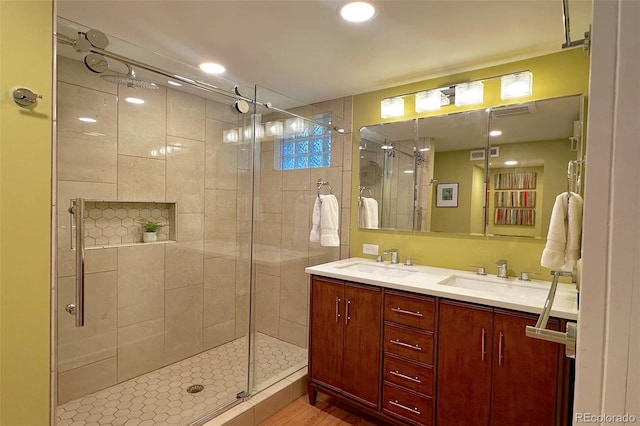 bathroom featuring a shower stall, double vanity, visible vents, and a sink