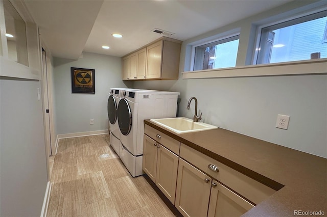 clothes washing area featuring visible vents, baseboards, washing machine and dryer, recessed lighting, and a sink