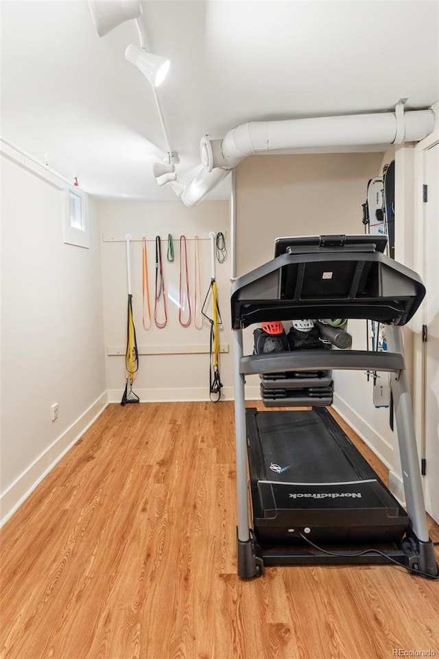 exercise area featuring baseboards and wood finished floors