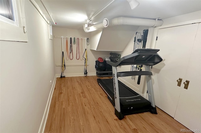 workout room featuring light wood-type flooring and baseboards