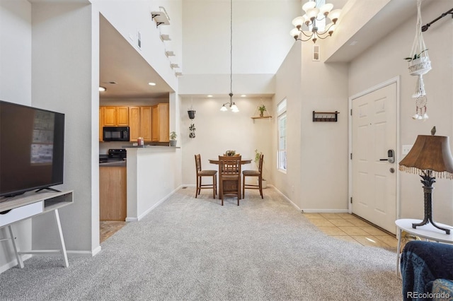 12728 Jasmine St Unit E, Thornton, CO 80602 - foyer entrance with visible vents, a towering ceiling, light carpet, baseboards, and a notable chandelier