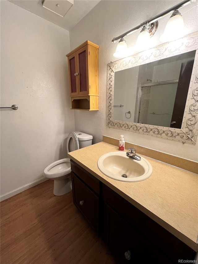 bathroom featuring large vanity, toilet, and hardwood / wood-style flooring