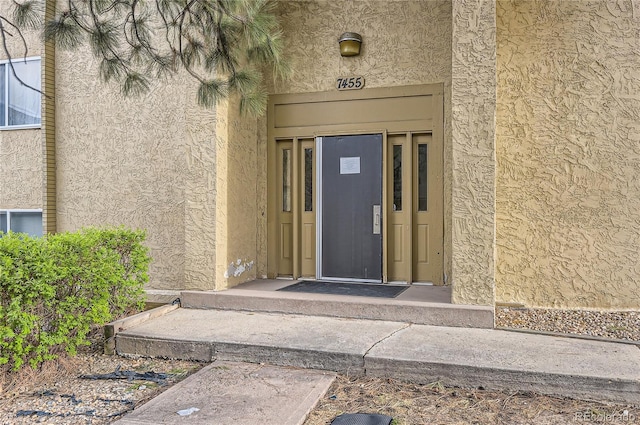 doorway to property with stucco siding