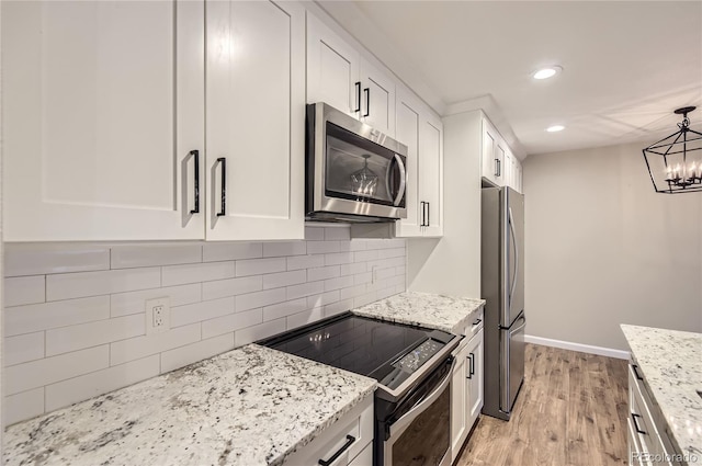 kitchen featuring stainless steel appliances, light wood-style flooring, white cabinets, baseboards, and recessed lighting